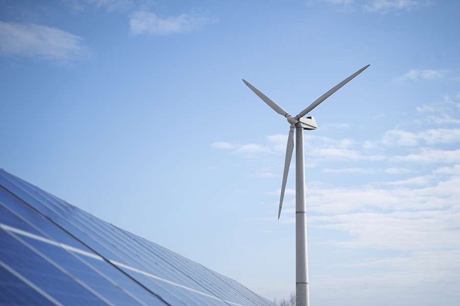 Renewable energy landscape with wind turbines and solar panels under a bright sky